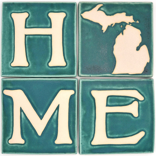 Four ceramic tiles spelling 'HOME' with a map of Michigan on a teal background